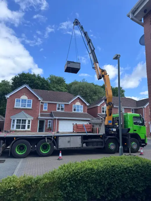 HIAB crane lifting a load over a residential property