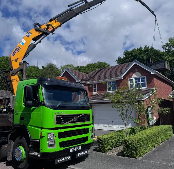 HIAB crane lorry lifting a load over houses