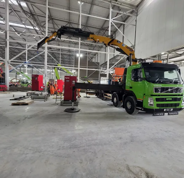 Green HIAB lorry inside an industrial building