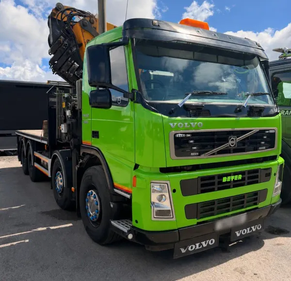 Green HIAB lorry with its crane arm raised