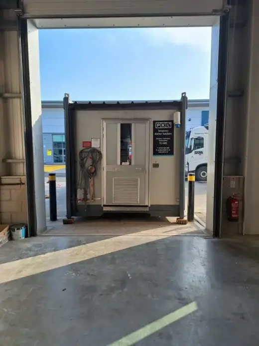 Portable cabin being moved through a warehouse loading door