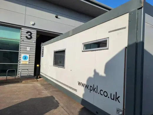 Portable welfare cabin positioned beside an industrial unit
