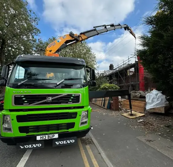 Green HIAB crane lorry on a narrow residential street