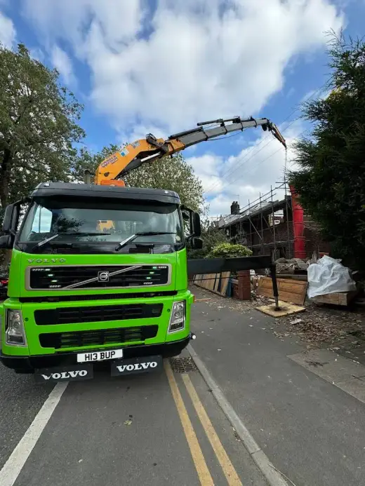 Green HIAB crane lorry on a narrow residential street