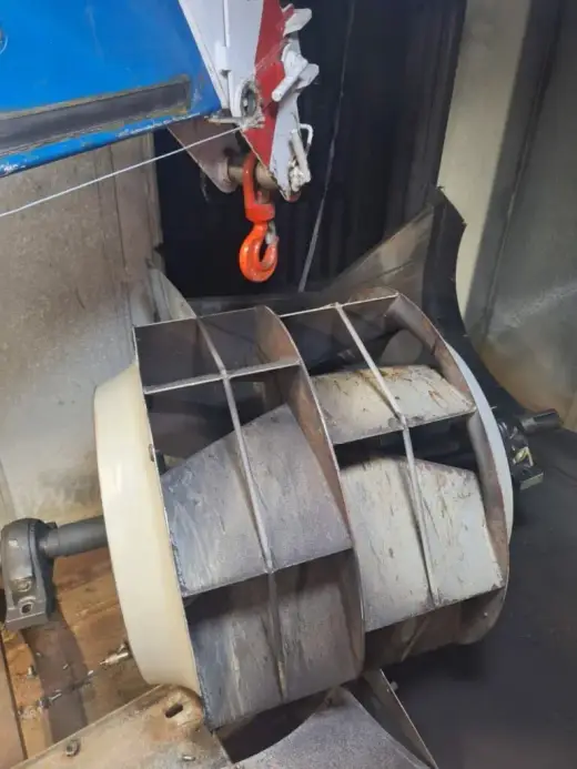 Crane hook lifting a large industrial fan impeller