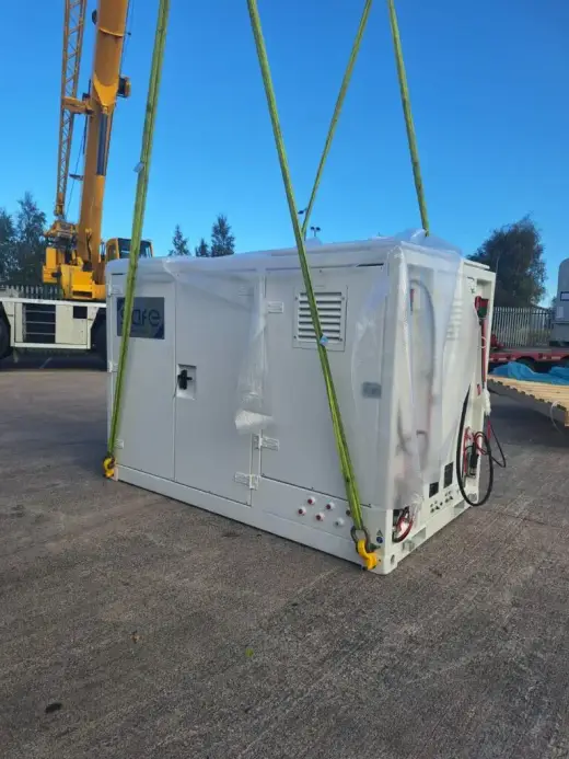 Mobile crane lifting a white plant unit on slings