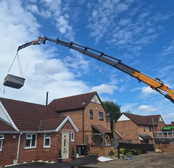 HIAB crane lifting a load over residential houses