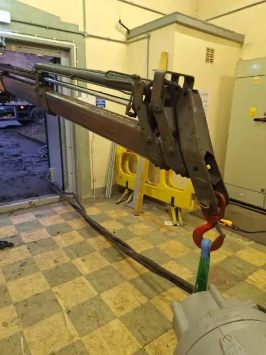 Lifting attachment reaching through a doorway into a plant room