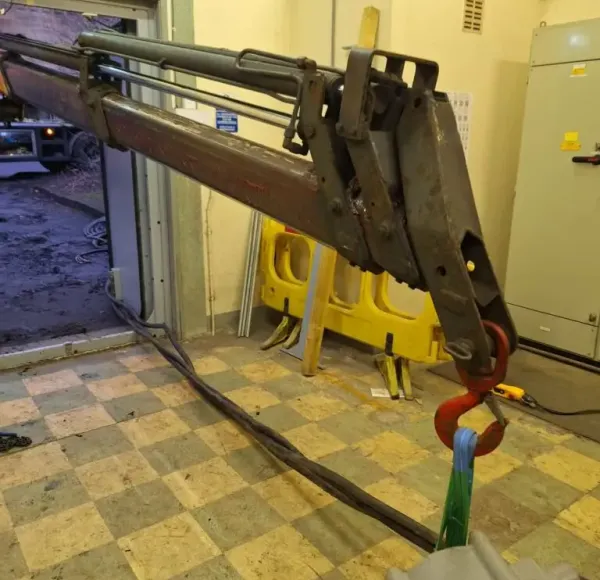 Lifting attachment reaching through a doorway into a plant room