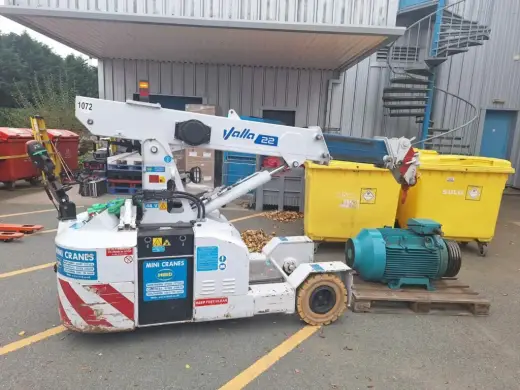 Pick-and-carry crane next to an electric motor on a pallet