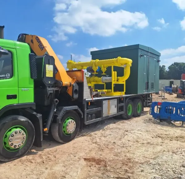 Green HIAB lorry delivering a compact crane to a construction site