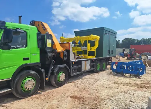 Green HIAB lorry delivering a compact crane to a construction site