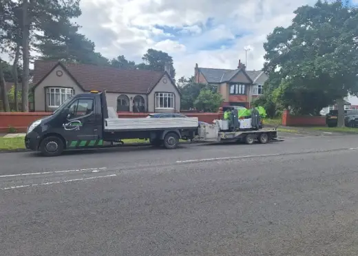 Pickup and trailer transporting a spider crane along a residential road