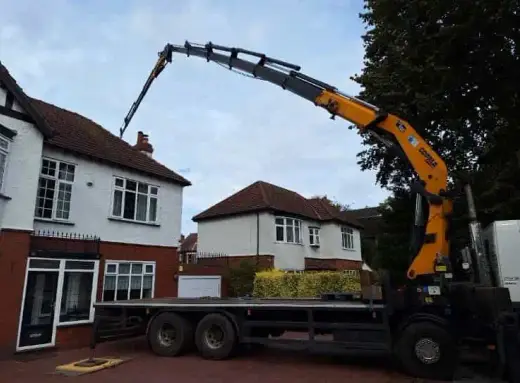 HIAB crane lorry lifting outside a detached house
