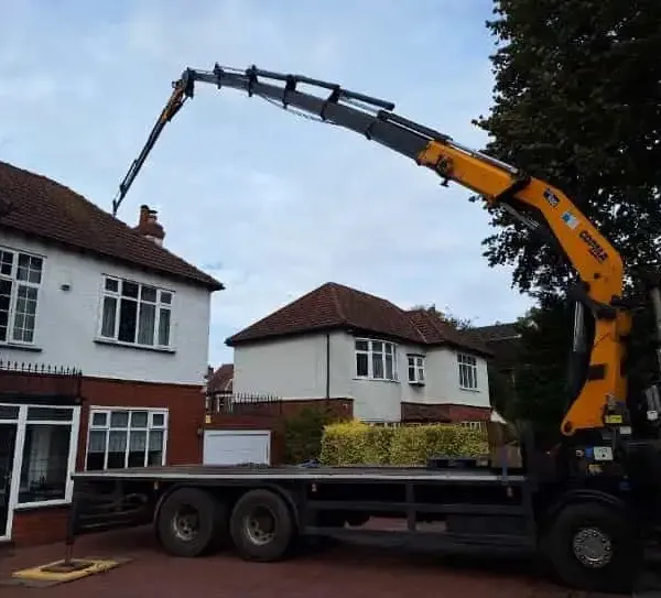 HIAB crane lorry lifting outside a detached house