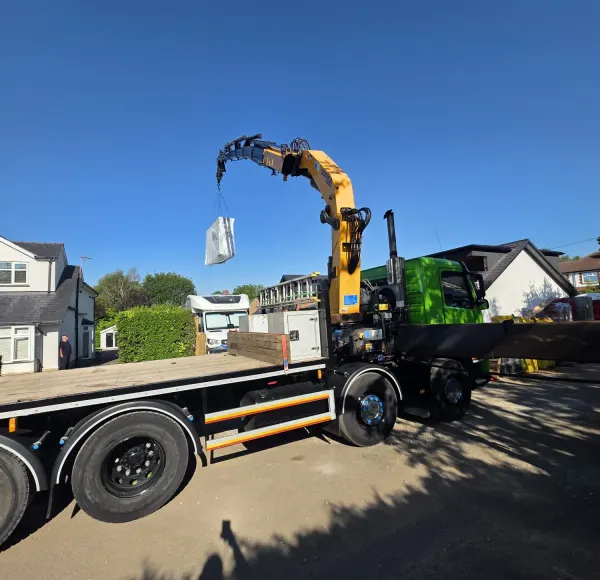 HIAB crane lorry lifting a load outside a house