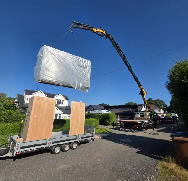 HIAB crane lifting a hot tub over a house