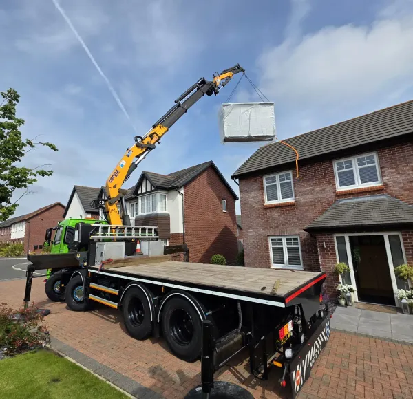 HIAB crane lorry lifting beside a detached house