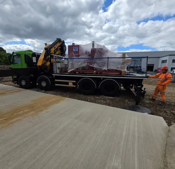 HIAB lorry unloading wrapped machinery at an industrial site