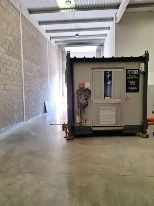 Portable cabin positioned at the end of a warehouse