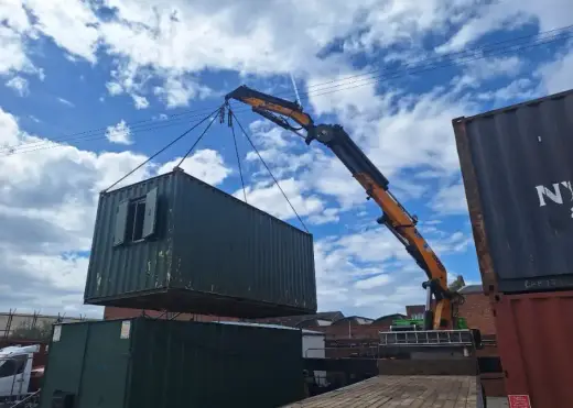 HIAB crane lifting a green shipping container