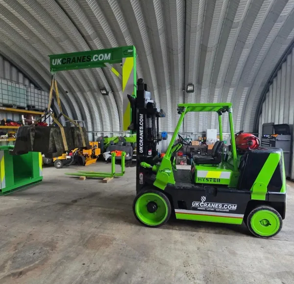 Branded forklift with lifting attachment inside a workshop