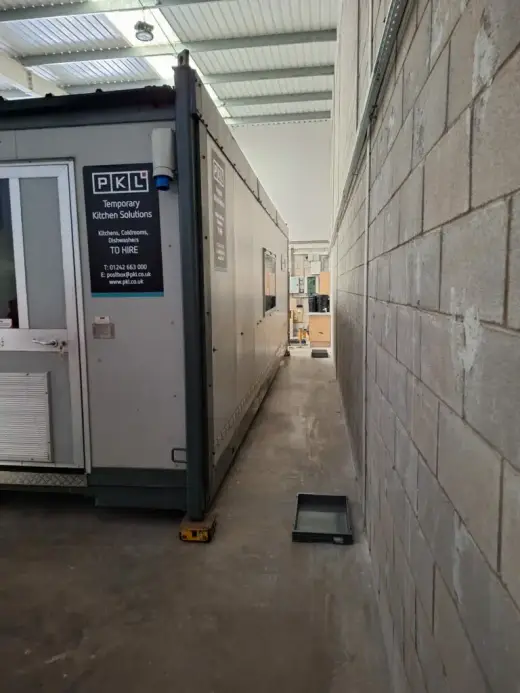 Portable cabin in a narrow warehouse corridor