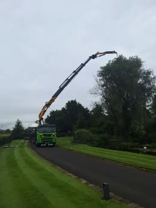 HIAB lorry on a driveway lined with lawns and trees