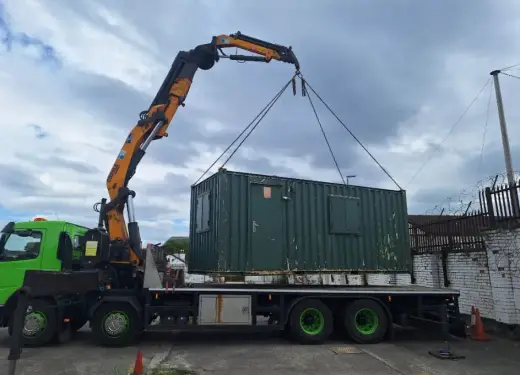 HIAB lorry lifting a green shipping container