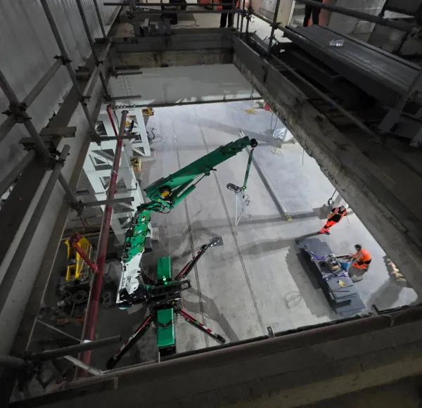 Green spider crane lifting inside a plant room
