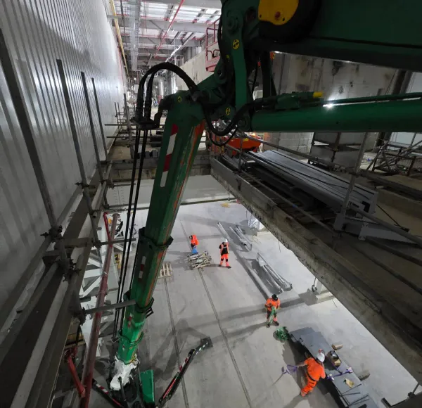 Spider crane lifting steelwork inside a building