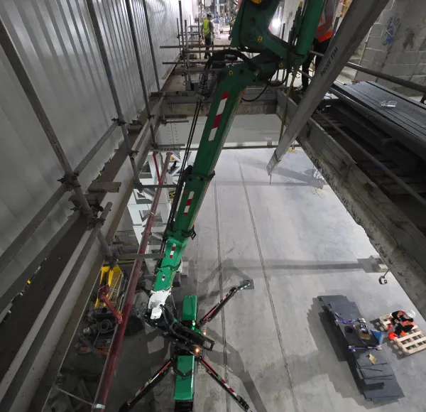 Spider crane boom rising inside a plant room
