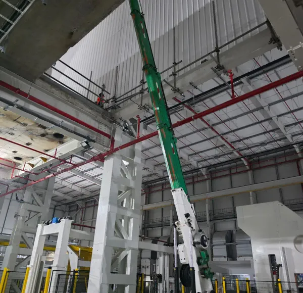 Spider crane lifting steelwork in a factory