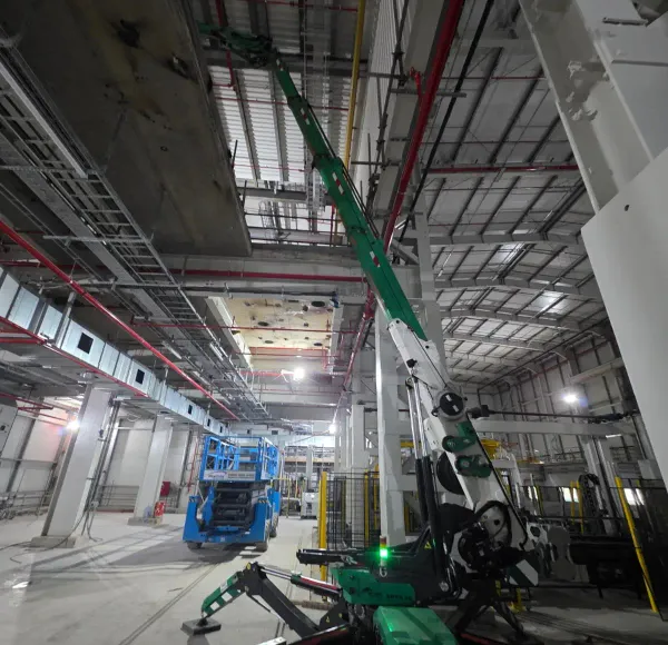 Spider crane lifting beside a scissor lift