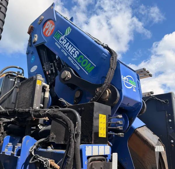 Close-up of a lorry-mounted crane arm against a cloudy sky