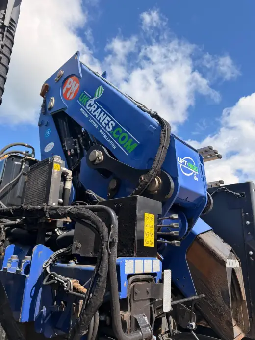 Close-up of a lorry-mounted crane arm against a cloudy sky